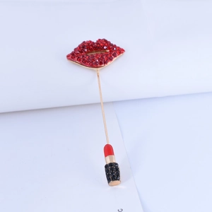 Detail of red rhinestone lips brooch with dangling lipstick pendant and gold-tone pin