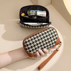 Chic houndstooth clutch bag with brown leather trim and gold zipper for women