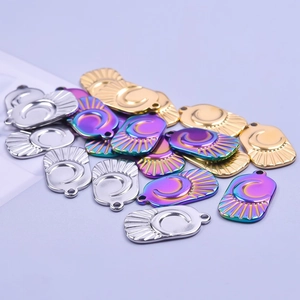 Macro shot of oval moon and sun pendants in silver, gold and rainbow stainless steel