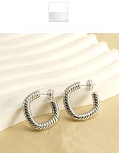 Detailed close-up of square C-shaped earrings with twisted thread pattern in silver