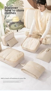 Detail of cream travel organizer set showing mesh bags for clothing sorting on a bed