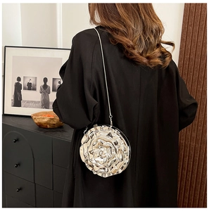 Detail of rose-shaped metallic gold clutch with 3D petals and a delicate chain strap