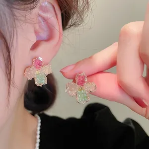 Detailed close-up of a four-leaf clover stud earring with pink and green crystals