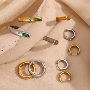 Artistic layout of 18K gold and silver star rings with zircon on silk and plaster