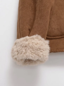 Détail de la manche d'une veste en daim marron avec bordure en fausse fourrure beige