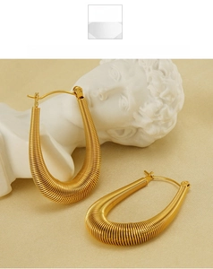 Detailed view of golden U-shaped earrings featuring intricate spiral metal wire wrapping