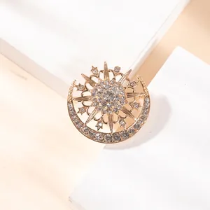 Exquisite sun and moon brooch in golden alloy with sparkling rhinestones on white stand