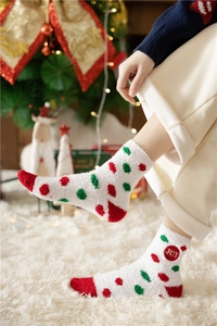 Detail of warm white coral fleece Christmas sock with red green dots and JOY embroidery
