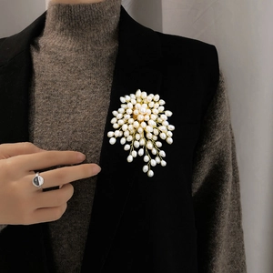 Detail of handmade freshwater pearl flower brooch pinned on a black suit jacket