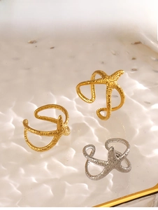 Detailed view of gold and silver starfish rings with hammered metal texture on water ripples