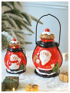 Détail de deux lanternes de Noël en céramique avec lumière chaude sur neige artificielle