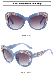 Detail of light blue cat-eye sunglasses with 3D floral accents and gradient grey lenses