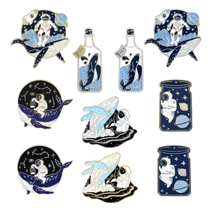 Whale and astronaut enamel pin set featuring cosmic ocean themes and star patterns