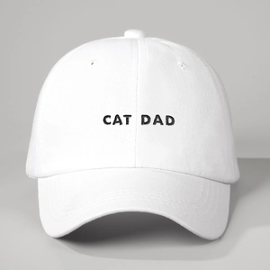 Close-up of Cat Dad embroidery on white cotton baseball cap with curved brim and eyelets
