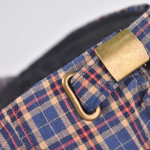 Dettaglio macro del cappello a quadri con tessuto intrecciato e fibbia in bronzo retrò