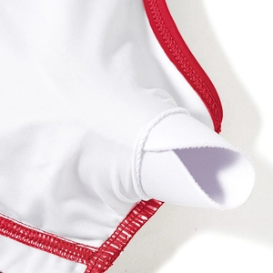 Detailed close-up of white swimwear lining with red trim and removable chest pad slot