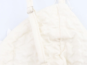 Détail du débardeur blanc avec bretelle réglable en métal et texture du tissu gaufré