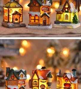 Detail of resin glowing Christmas village houses with snowy roofs and warm LED light