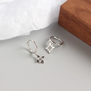Détail macro d'une boucle d'oreille étoile en argent avec émail noir et zircons blancs