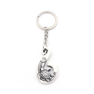 Silver alloy keychain featuring a fish hook pendant with turtle and wave engravings