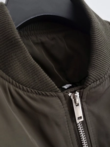 Detail showing army green bomber jacket with ribbed collar and metal zipper in size XS