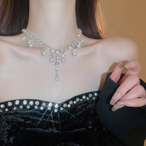 Detail view of a silver pearl tassel necklace with sparkling teardrop zircon on a model
