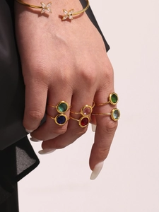 Detailansicht goldener Ringe mit bunten Steinen und Zirkon-Schmetterlingsarmreif