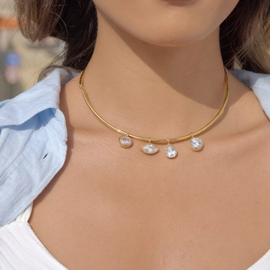 Détail du collier choker doré en acier inoxydable avec quatre pendentifs en zircon