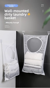 Detail view of white wall-mounted mesh laundry bag with two adhesive hooks for bathroom storage