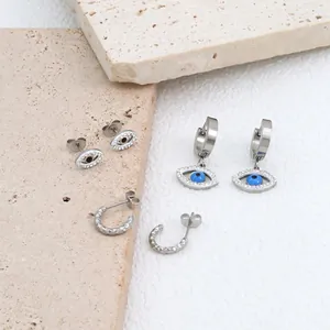 Detailed macro view of evil eye hoop earrings with blue stones and C-shaped metal studs