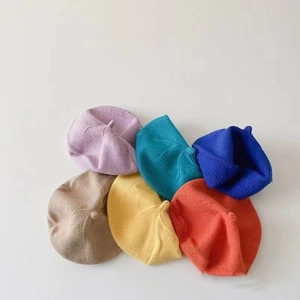 Close-up of knit beret caps showing various colors and fine fabric texture details
