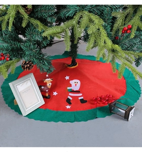 Detailed view of red and green felt Christmas tree skirt with Santa Claus applique