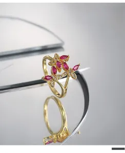 Detail view of gold butterfly ring with ruby marquis stones and pavé cubic zirconia