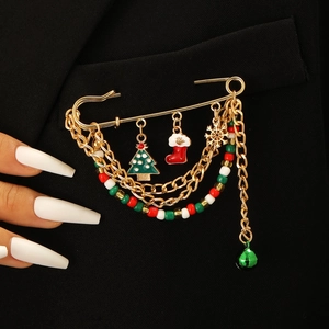 Detail of Christmas themed safety pin brooch with tree and snowflake charms on a blazer