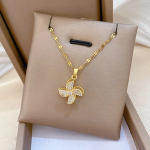 Close-up of golden windmill pendant with sparkling zircons in a brown jewelry box