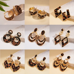 Set of nine leopard print and gold geometric heart earrings in various hoop styles