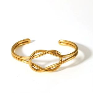 Detailed view of a gold knot open cuff bracelet featuring double intertwined wires