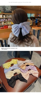 Détail de grandes pinces à cheveux à nœuds en satin de couleurs variées pour femmes