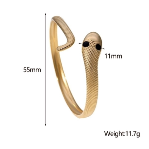 Detailed view of golden snake bracelet with scale texture and gemstone eyes, 55mm inner diameter