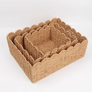Three-piece nesting woven storage baskets with elegant scalloped edges in natural wood tone