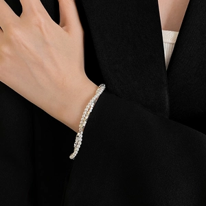 Detailed close-up of double-layer pearl bracelet with silver square beads on wrist