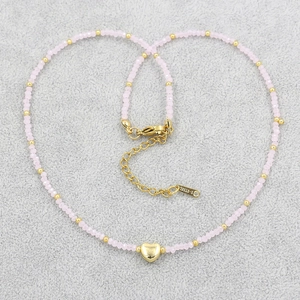 Detailed macro view of pink crystal beads and golden heart pendant on an S-Steel necklace