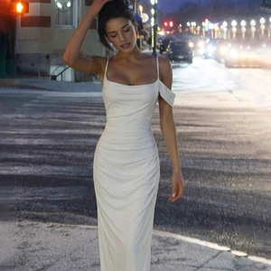 Close-up of white backless slip dress featuring side ruching and silky fabric texture