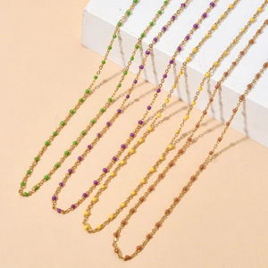 Detail of French vintage gold necklaces with green, purple, yellow, and brown beads