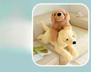 Detail von Plüsch-Retriever-Spielzeugen in Braun und Creme auf einem weichen Ledersofa