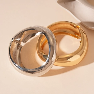Polished gold and silver wide twisted geometric bracelets with metallic glossy finish