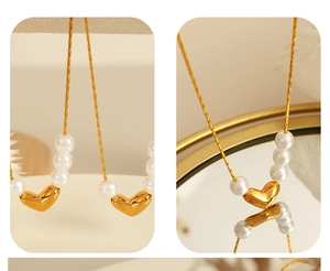 Détail d'un collier pendentif cœur doré avec perles blanches et une fine chaîne délicate