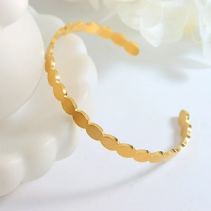 Minimalist gold oval link bracelet with wavy design and polished finish in open style