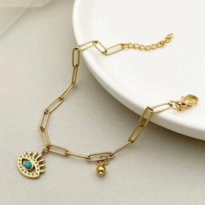 Detailed shot of golden paperclip chain bracelet with turquoise evil eye charm and bead
