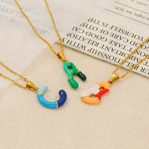 Macro shot of colorful enamel alphabet pendants with gold-plated stainless steel chains